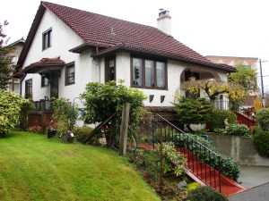 This house at Green Lake conveys its Spanish style with its stucco walls, red tile roof and front veranda.