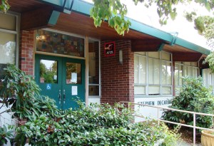 "Stephen Decatur" is written beside the front entrance of Decatur School, but partially obscured by shrubbery.