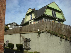 The Big Green House at 7321 35th Ave NE has a retaining wall around it, showing that the street level has been cut down.