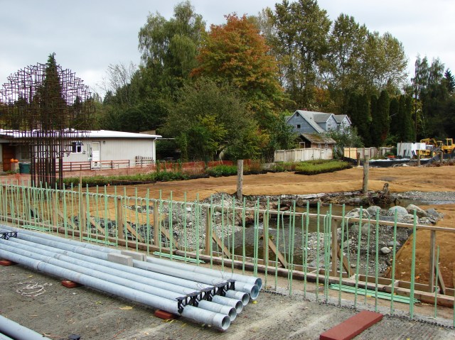 On the east side of 35th Ave NE a floodplain is being created.  The Memory Tree art installation is at left.  In the foreground is the roadway which is being rebuilt after installation of culverts under 35th Ave NE.