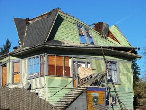 The demolition shovel grasped the front walls and pulled them inward.